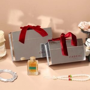Luxury silver cardboard gift box closed – high-shine metallic finish with deep-red velvet ribbon